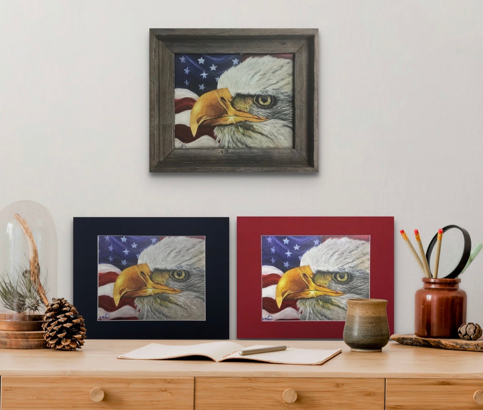 Three prints in various color mats and frames of bald eagle against a waving American flag backdrop